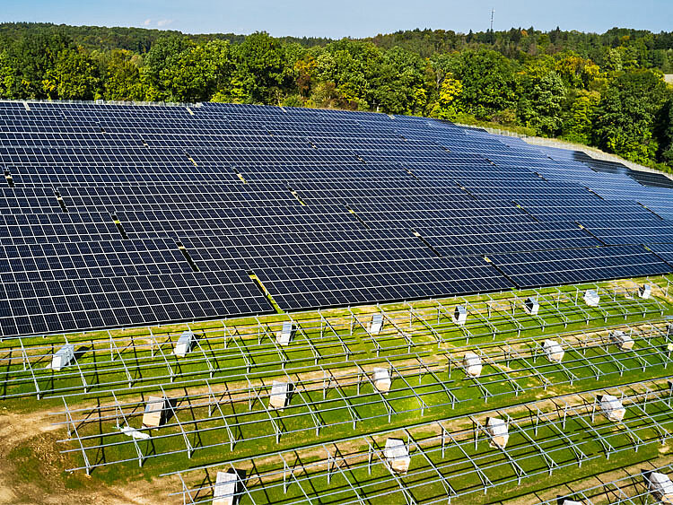 In the background, there is a fully constructed solar installation, and in front of it, the framework is ready for the module assembly.